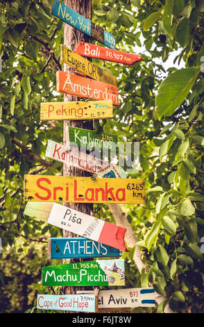 Funny directions signpost with distance to many different countries, cities and places Stock Photo