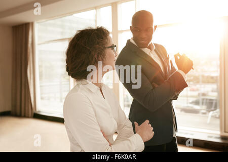 Two young business people discussing work during a business presentation in conference room at a hotel. Smiling business people Stock Photo