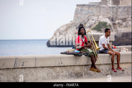 Teens Cubans to laying bricks of Malecon trombonist, musician outdoors with dreadlocks and trombone,, Street Scene, La Habana, C Stock Photo
