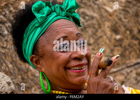 old heavily made Cuban woman with green hair bow smoking a Havana cigar, Cuban cigar with lacquered fingernails with Cuban Flag, Stock Photo