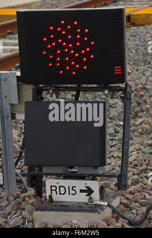 A matt black painted 'Fixed red' aspect signal ground mounted with the LED lights showing in the upper section of the signal Stock Photo