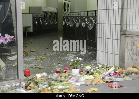 Paris, France. 17th Nov, 2015. Some flowers have been laid in front of the launderette, next to the Café Bonne Bière, which has been damaged during the Paris attacks. Parisians and tourists continue to visit the memorials for the people killed in the terrorists attacks in Paris, to lay down flowers and candles and to pay their respect. Over 130 people have been by terrorist from the Islamic State. Credit:  Michael Debets/Pacific Press/Alamy Live News Stock Photo