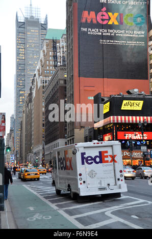 A Fedex Truck drives past a large sign advertising Mexico on a street in New York City Stock Photo