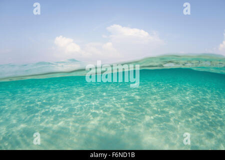 Sunlight ripples across a shallow sand flat in Indonesia. This tropical region is known for its beautiful coral reefs and high m Stock Photo