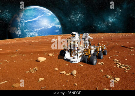 A team of astronauts explore a barren moon on a rover. The moon's water-covered parent planet rises over the horizon. Stock Photo