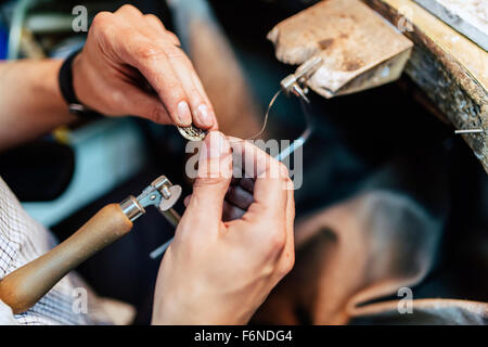 Jeweler making jewelry on workbench Stock Photo