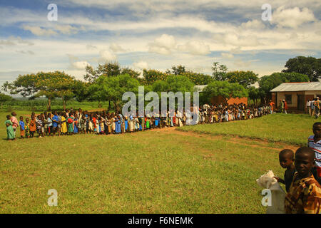 School children queuing for food from a feeding programme in the village of Nyombe, Malawi, Africa Stock Photo