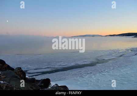 colorful dawn sky over mist and ice shrouded sea landscape in icy cold arctic circle winter time Stock Photo