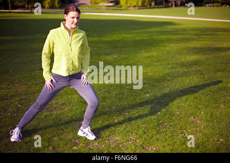 Young woman stretching her legs in a park Stock Photo
