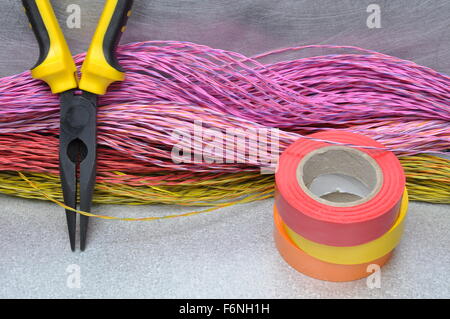 Multicolored pliers, insulating tapes and cables on metal surface Stock Photo