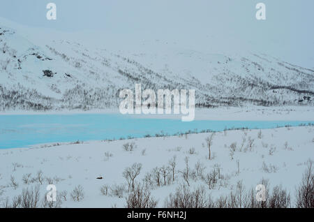 vibrant blue mountain lake ice in winter landscape Stock Photo