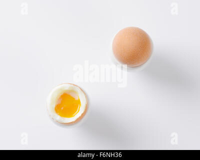 two soft boiled eggs in egg cups on white background Stock Photo