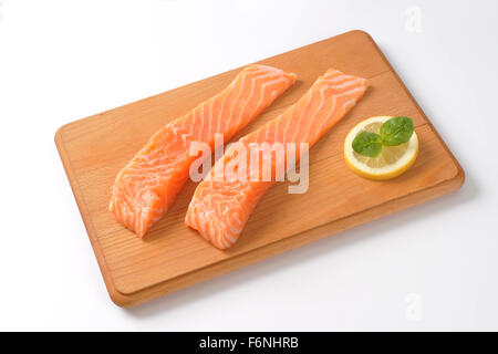 two raw salmon fillets on wooden cutting board Stock Photo