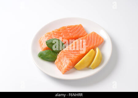 two raw salmon fillets on white plate Stock Photo