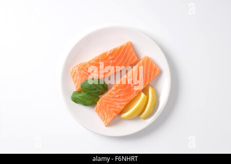 two raw salmon fillets on white plate Stock Photo