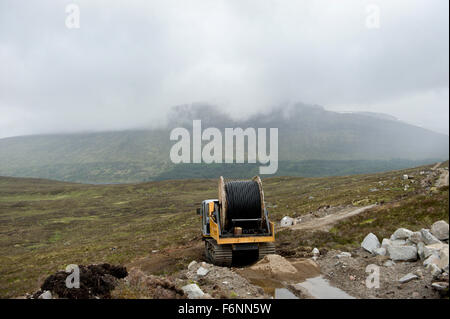 Installation of power supply cables over remote scottish hills Stock Photo
