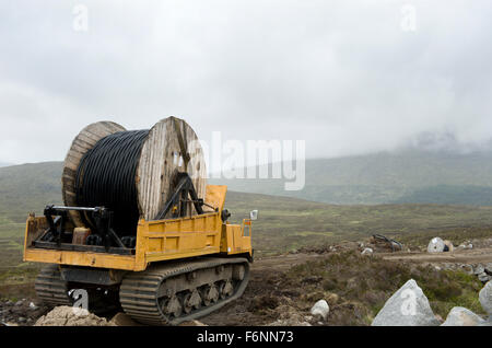 Installation of power supply cables over remote scottish hills Stock Photo