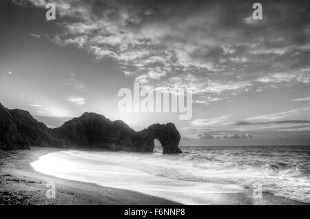 Winter sunrise over Durdle Door on Jurassic Coast in black and white