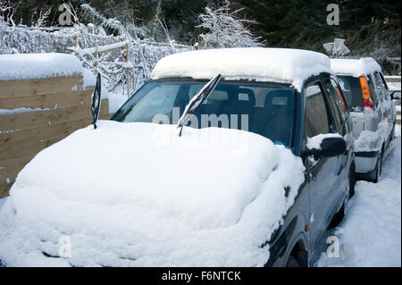 Snow covered cars outside a property in rural Aberdeenshire Stock Photo