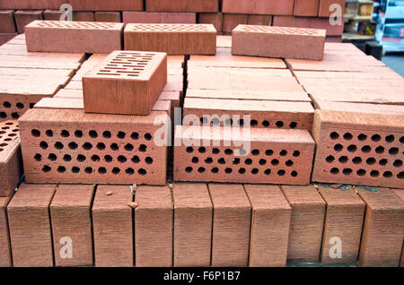 Stack of red clay bricks with holes in market Stock Photo
