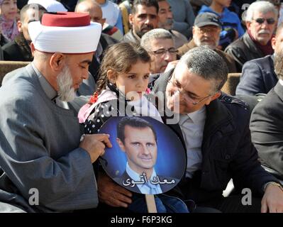 Damascus. 18th Nov, 2015. A Palestinian girl holds a portrait of Syrian President Bashar al-Assad during a celebration held in the district of Hussainiyeh, in Damascus, capital of Syria, on Nov.18, 2015. Hussainiyeh, which houses some Palestinian refugees in Damascus, has suffered intense battles between the rebels and the Syrian army. © Ammar/Xinhua/Alamy Live News Stock Photo