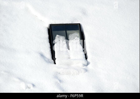 Conservation style velux window on the roof of a converted steading in Scotland, almost covered in snow Stock Photo