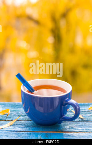 yellow autumn leaves Tea Cup on a red background Stock Photo - Alamy