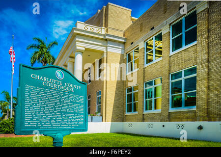 The Neo-Classical Charlotte County Courthouse building with historical marker, flag and blue skies in Punta Gorda, Florida Stock Photo