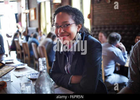 Black woman sitting at restaurant table Stock Photo