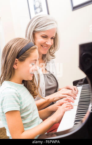 Caucasian woman giving student piano lessons Stock Photo
