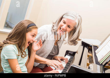 Caucasian grandmother and granddaughter playing piano Stock Photo