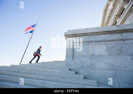 Mixed race businessman walking on courthouse steps Stock Photo