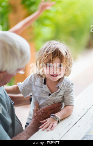 Caucasian grandfather and grandson sitting at table Stock Photo
