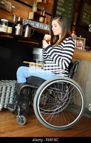 Paraplegic woman in wheelchair drinking coffee Stock Photo