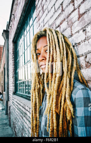 Black woman with dreadlocks at brick wall Stock Photo