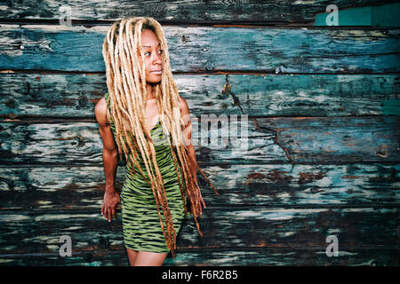 Black woman standing at wooden wall Stock Photo