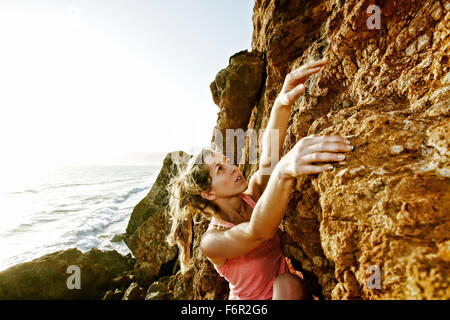 Woman climbing rock formation