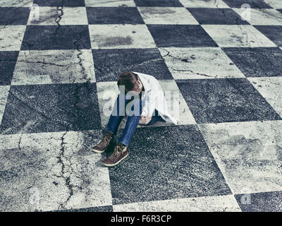 Conceptual, lonely man and checkered ground Stock Photo