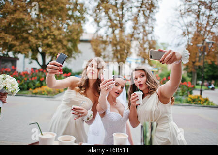 Young bridesmaid with bride doing selfie Stock Photo