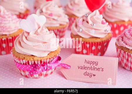 Pink Valentine cupcakes with the words 'Happy Valentine's day' on a tag. Stock Photo