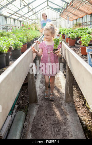 Female gardener and children in greenhouse Stock Photo