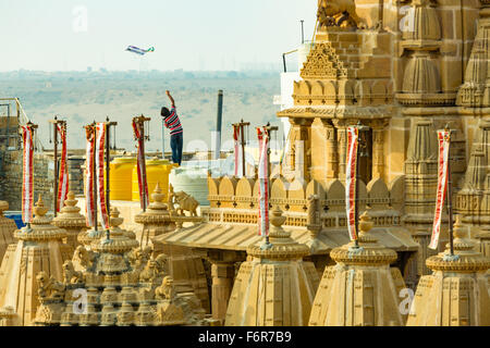Jaisalmer, India - January 24, 2015: Boy flying a kite on rooftop beside a Jain temple Stock Photo