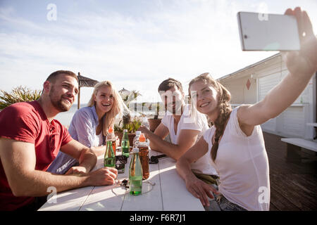 Group of friends taking a self portrait in beach bar Stock Photo