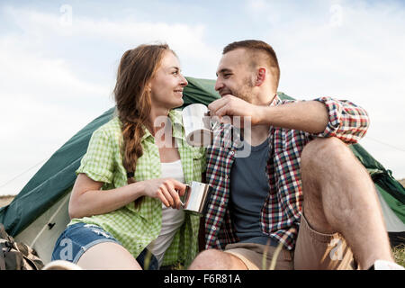 Happy couple at campsite having a cup of coffee Stock Photo