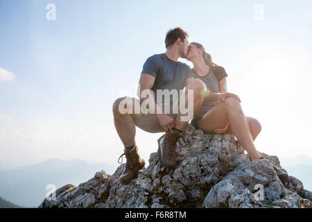 Young couple kissing on mountain peak Stock Photo