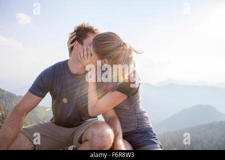 Young couple kissing on mountain peak Stock Photo