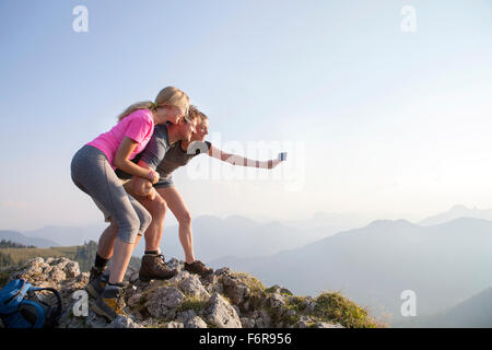 Group of friends taking picture on mountain peak