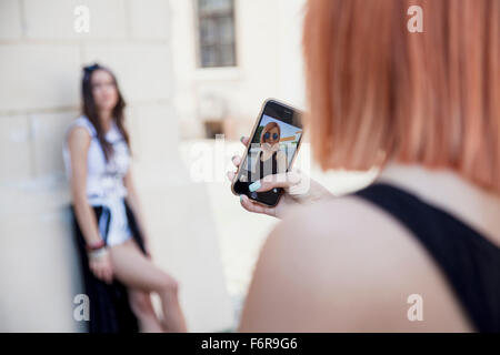 Young woman taking picture of girlfriend Stock Photo