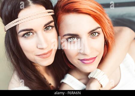 Portrait of young women in hippie style fashion embracing Stock Photo