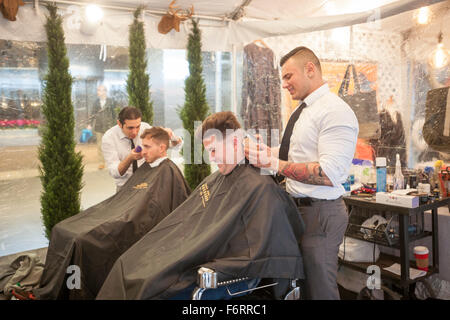 New York, USA. 19th Nov, 2015. Customers get haircuts from 'Made Men' in 'Square Village' outside the New York Stock Exchange during Square's initial public offering on Thursday, November 19, 2015. The NYSE and Square set up a 'Square Village' outside the exchange with merchants using Square setting up at the fair. Credit:  Richard Levine/Alamy Live News Stock Photo